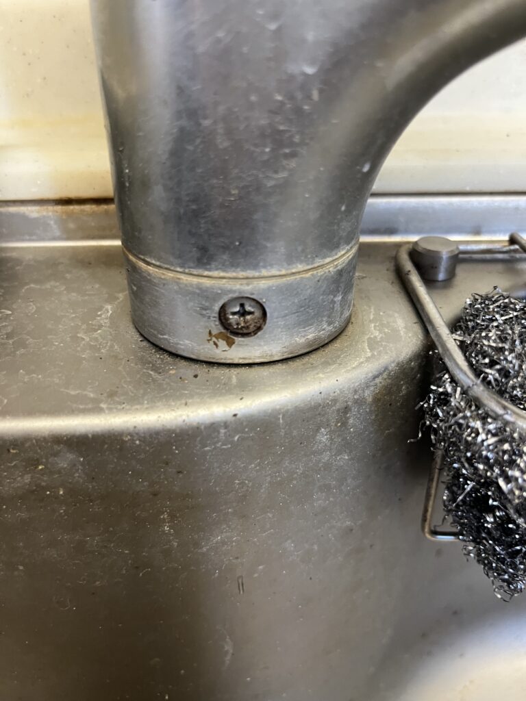 この水栓は下から締め付けるタイプではなく上部施工のタイプなのでビスを外していきます。